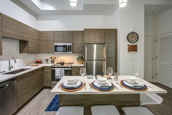 a kitchen with wooden cabinets and stainless steel appliances at Altis Grand Central, Tampa, 33606